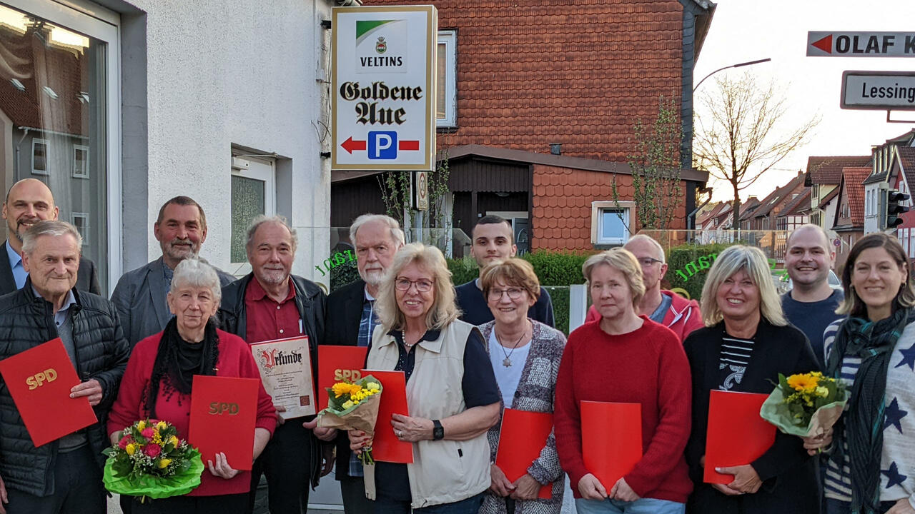 Viele Personen mit Ehrenurkunden posieren in einer Gruppe für ein Foto. 