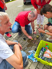 Nils Gerke und Petra Schultheis putzen am Postplatz die Stolpersteine für die Familie Pelz
