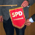 Drei Personen halten SPD Wimpel hoch